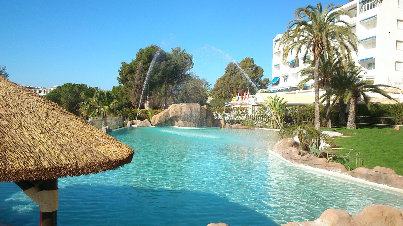Hotel resort con piscina de arena y rocas decorativas