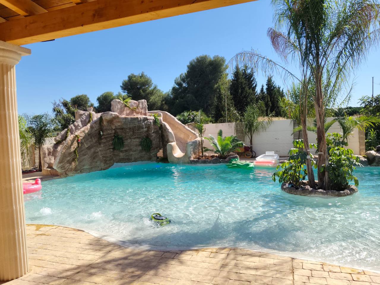 Piscina de arena con cascada y tobogán integrado